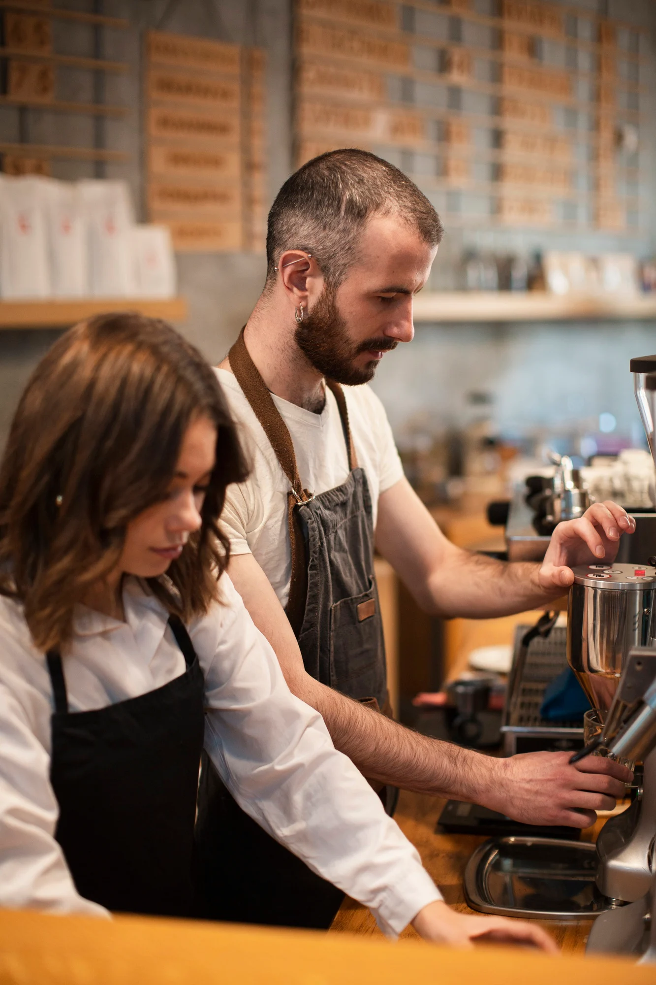 Two baristas working together at an espresso machine
